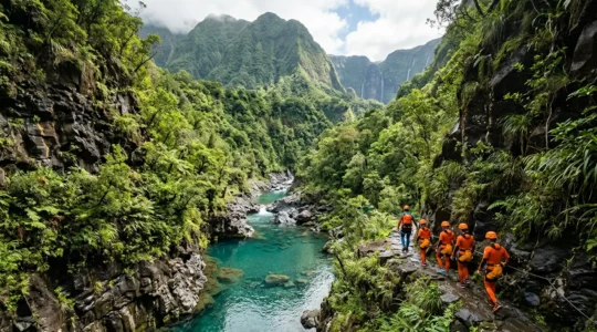 Groupe de canyonistes débutants en combinaison néoprène dans un canyon tropical de La Réunion, guidé par un professionnel lors d'un passage aquatique sécurisé