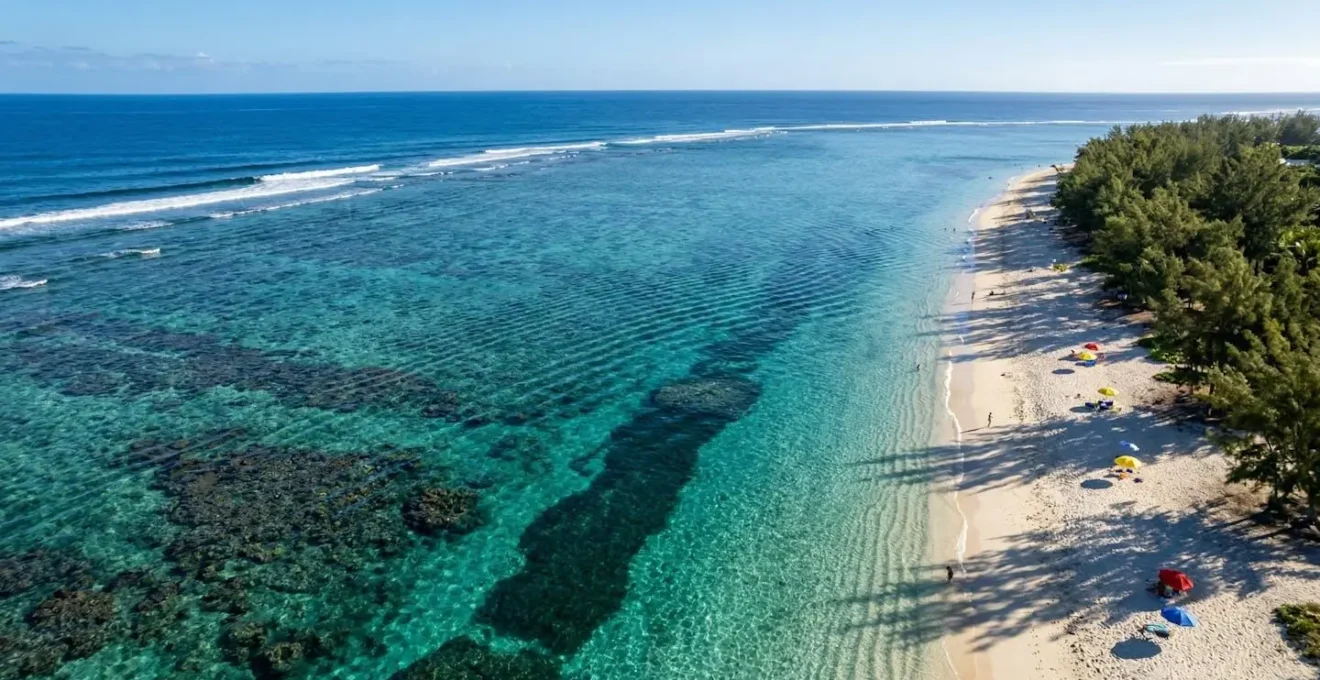 Vue aérienne du lagon turquoise de Saint-Gilles à La Réunion avec plage de sable blanc et filaos ombrageants