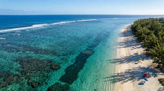 Vue aérienne du lagon turquoise de Saint-Gilles à La Réunion avec plage de sable blanc et filaos ombrageants