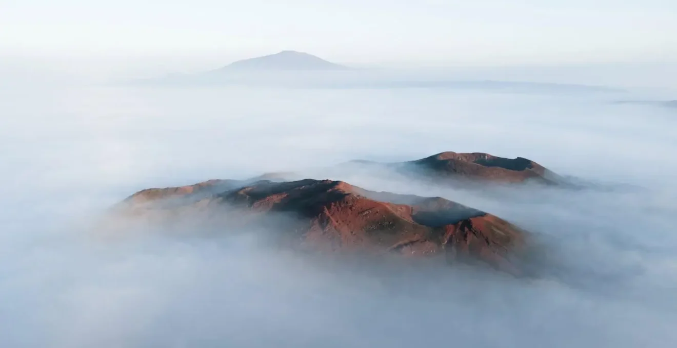 Brume matinale diffusant la lumière sur les formations volcaniques de la Plaine des Sables