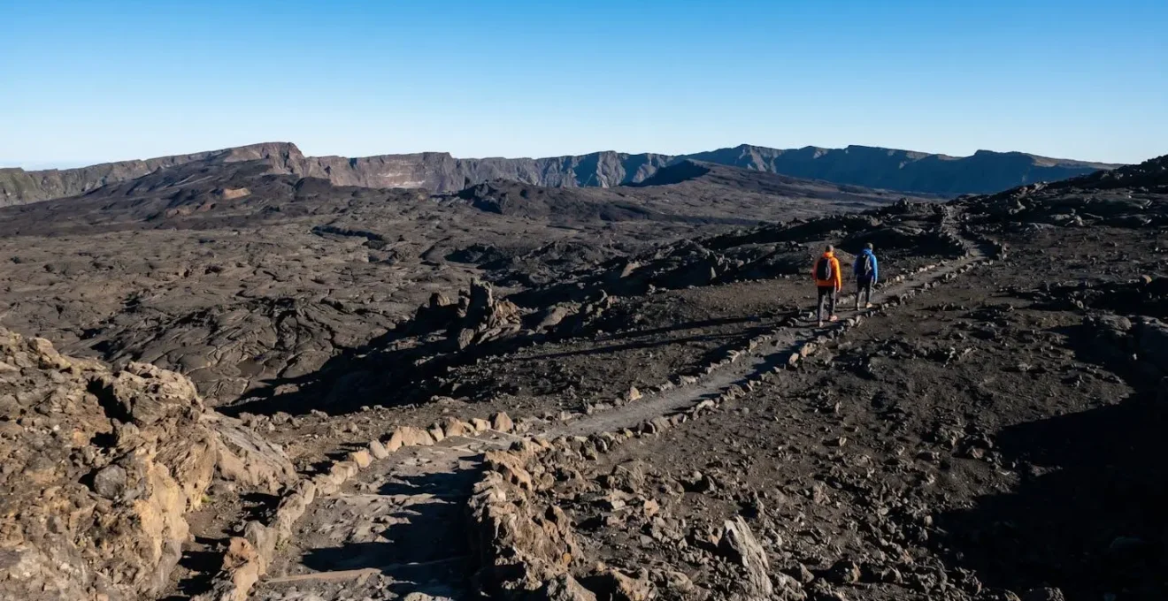 Randonneurs sur les sentiers du Piton de la Fournaise avec vue dégagée sur le cratère en hiver austral